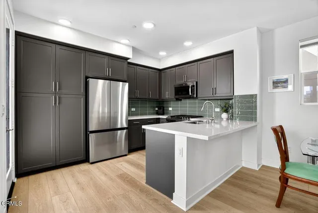 a kitchen with stainless steel appliances a refrigerator stove microwave and sink