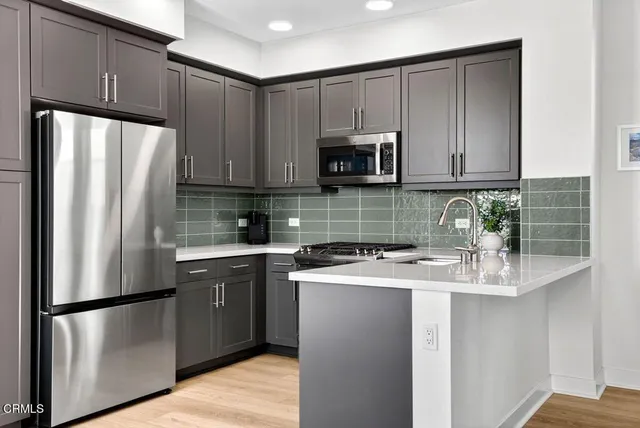a kitchen with stainless steel appliances granite countertop a refrigerator stove a sink and dishwasher