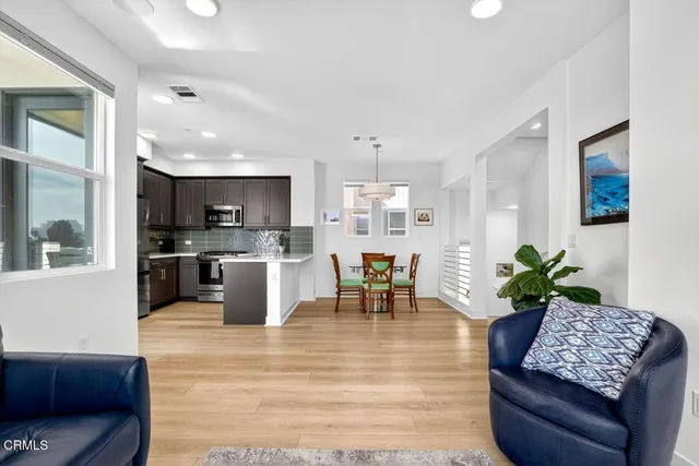 a living room with furniture and a kitchen area