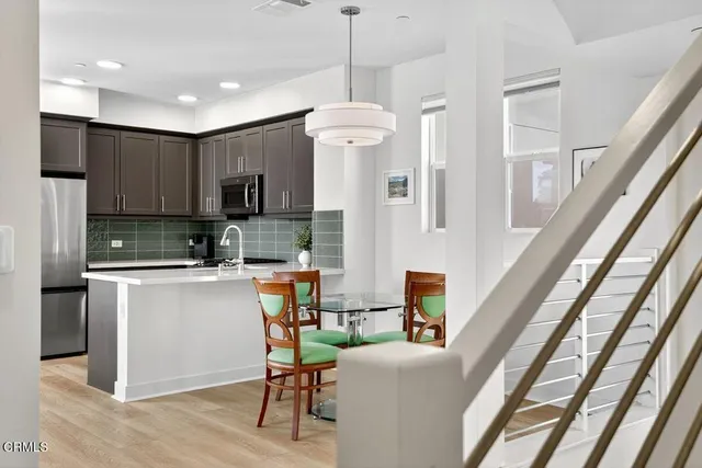 a kitchen with stainless steel appliances granite countertop a refrigerator and a stove top oven