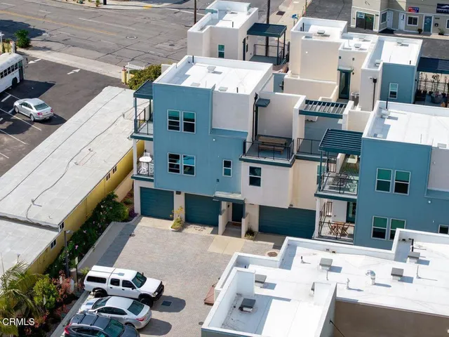 a picture of a patio with couches potted plants and other items