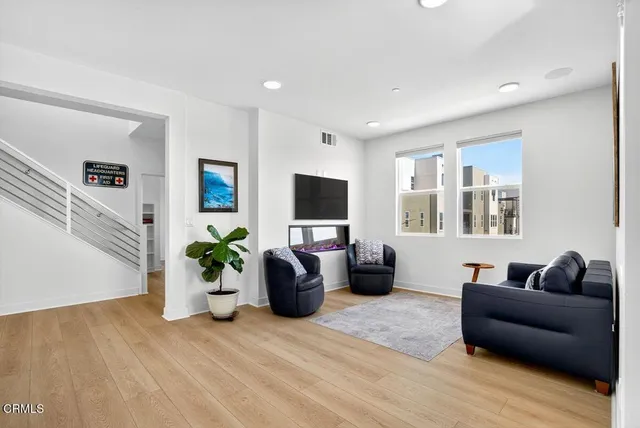 a living room with furniture potted plant and a flat screen tv
