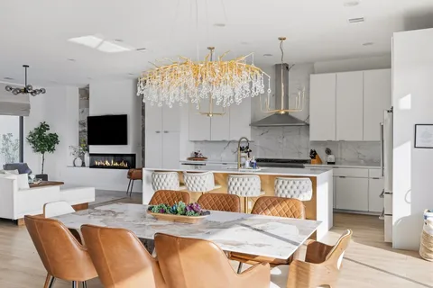 a kitchen with stainless steel appliances kitchen island granite countertop a stove and a white cabinets