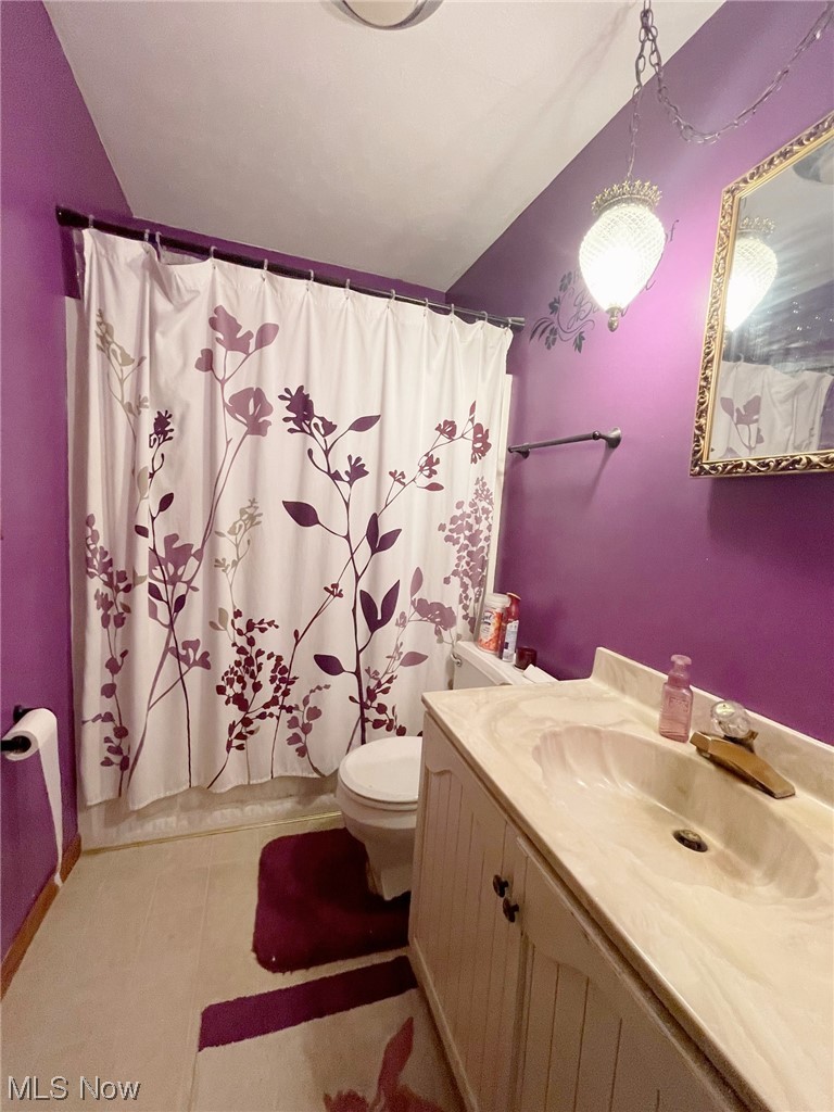 15508 West Calla Road Beloit, OH 44609 - Photo 12 of 19 Bathroom with light tile floors, lofted ceiling, mirror, and vanity
