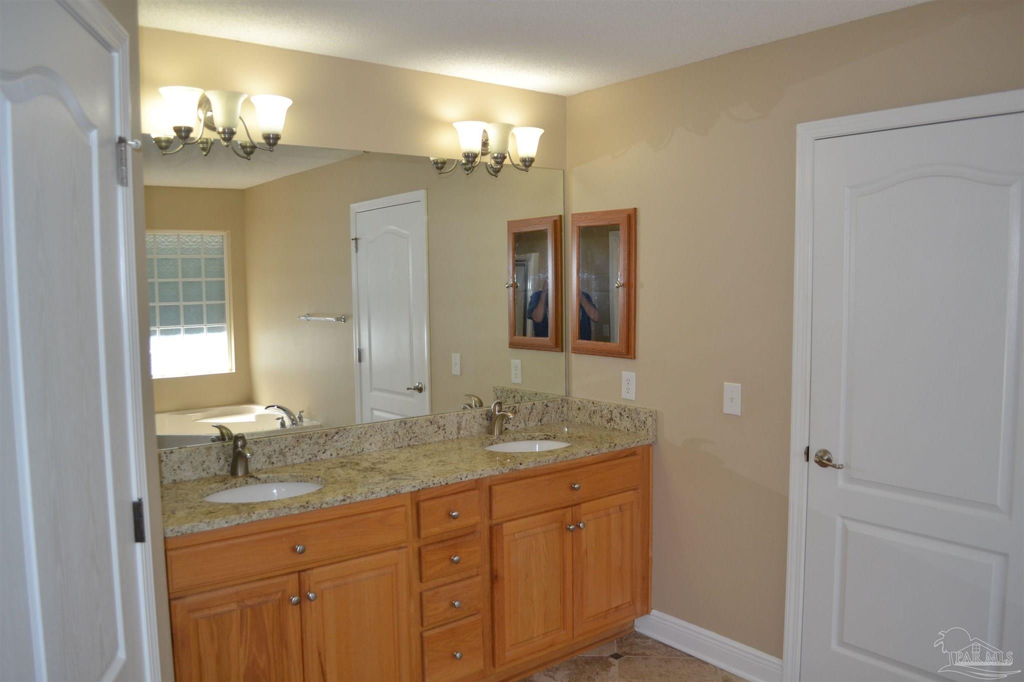 3055 Wallace Lake Road Pace, FL 32571 - Photo 29 of 33 a bathroom with a granite countertop double vanity sink and a mirror