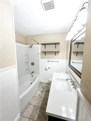 a bathroom with a tub sink and toilet