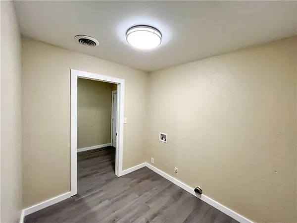 an empty room with wooden floor and mirror