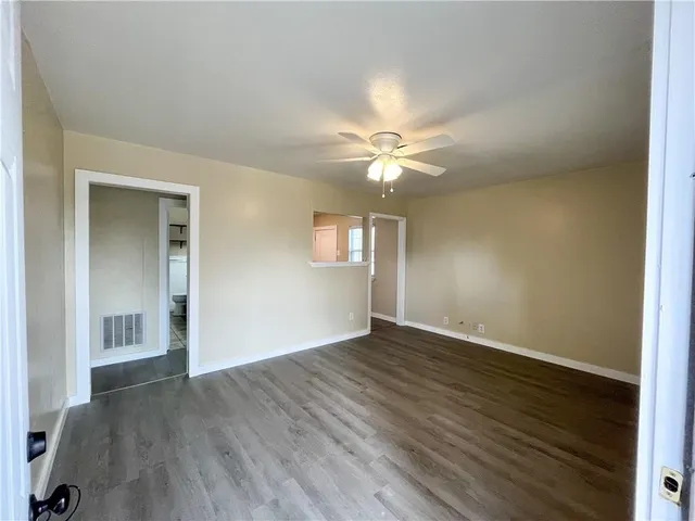 an empty room with wooden floor and window