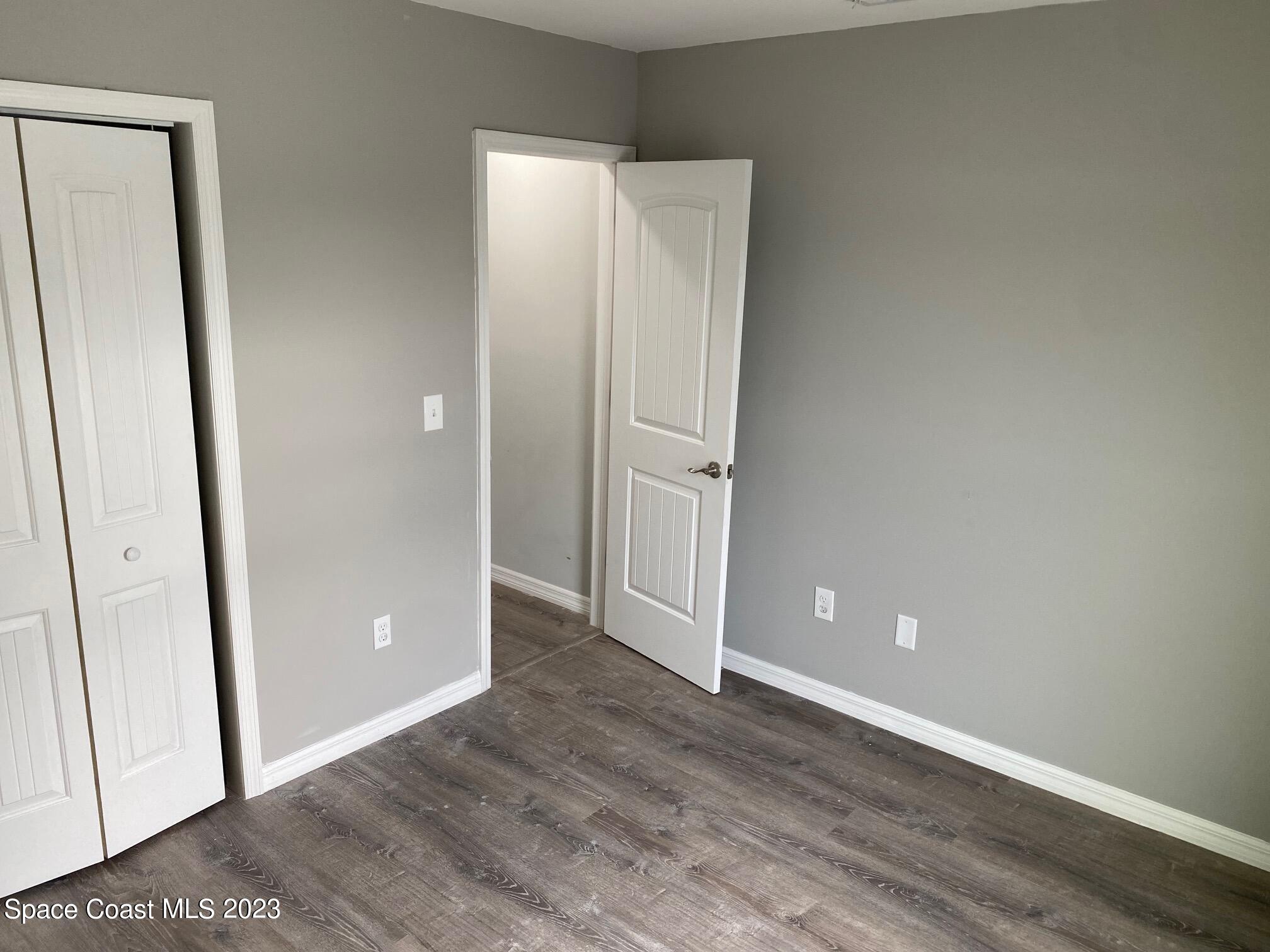 2944 Century Oaks Circle Malabar, FL 32950 - Photo 11 of 16 an empty room with wooden floor and entrance