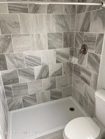 a bathroom with a toilet and a shower