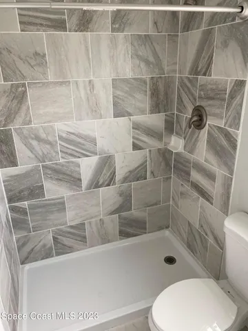 a bathroom with a toilet and a shower