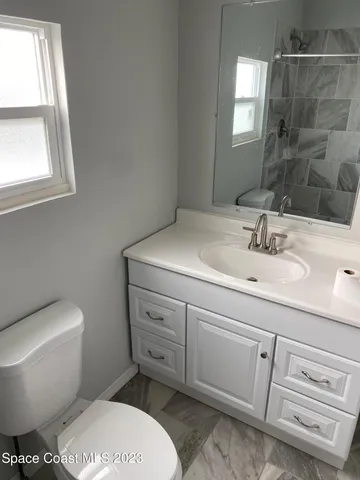 a bathroom with a sink toilet and window