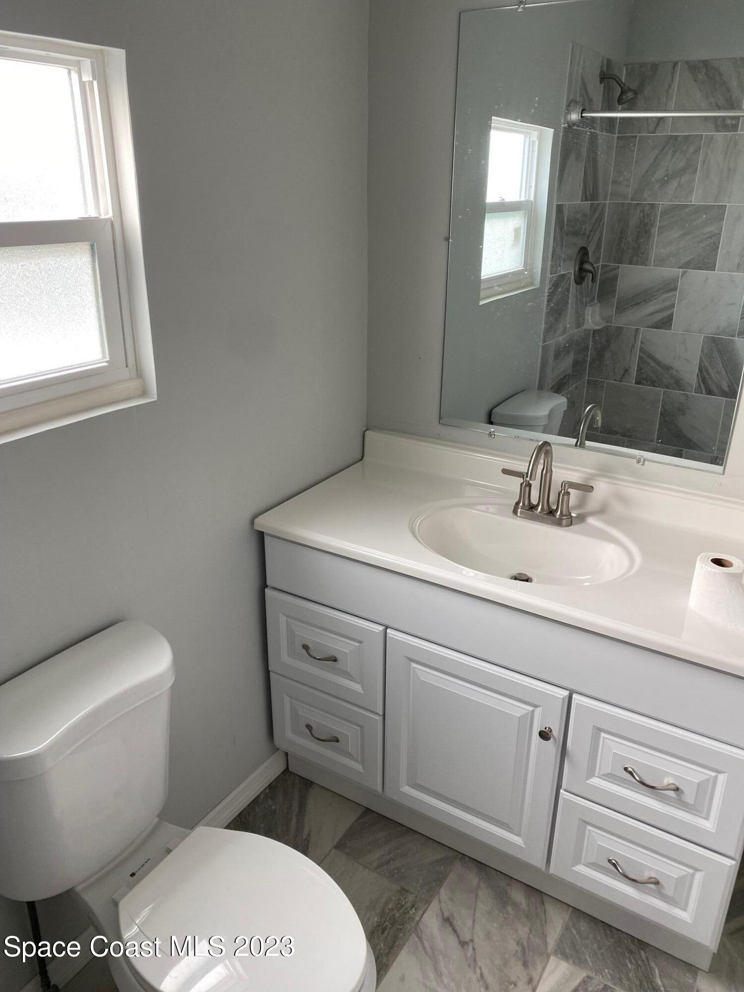 2944 Century Oaks Circle Malabar, FL 32950 - Photo 15 of 16 a bathroom with a sink toilet and window