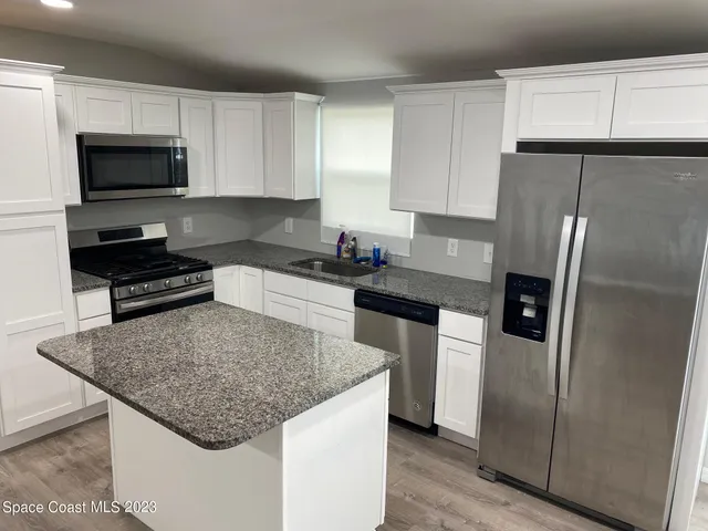 a kitchen with a center island and stainless steel appliances