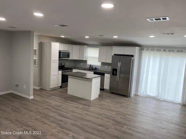a kitchen with stainless steel appliances granite countertop a refrigerator and a stove