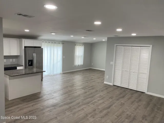 a view of a kitchen with a sink and a refrigerator