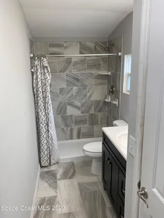 a bathroom with a toilet a sink and shower