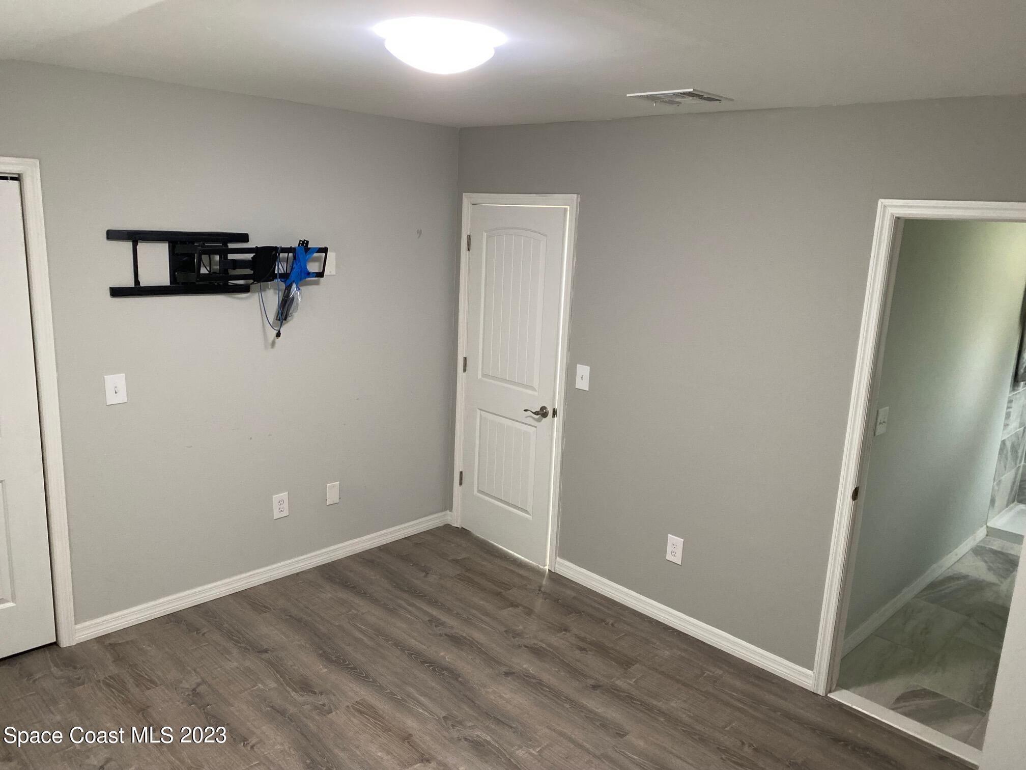 2944 Century Oaks Circle Malabar, FL 32950 - Photo 8 of 16 an empty room with wooden floor and a ceiling fan