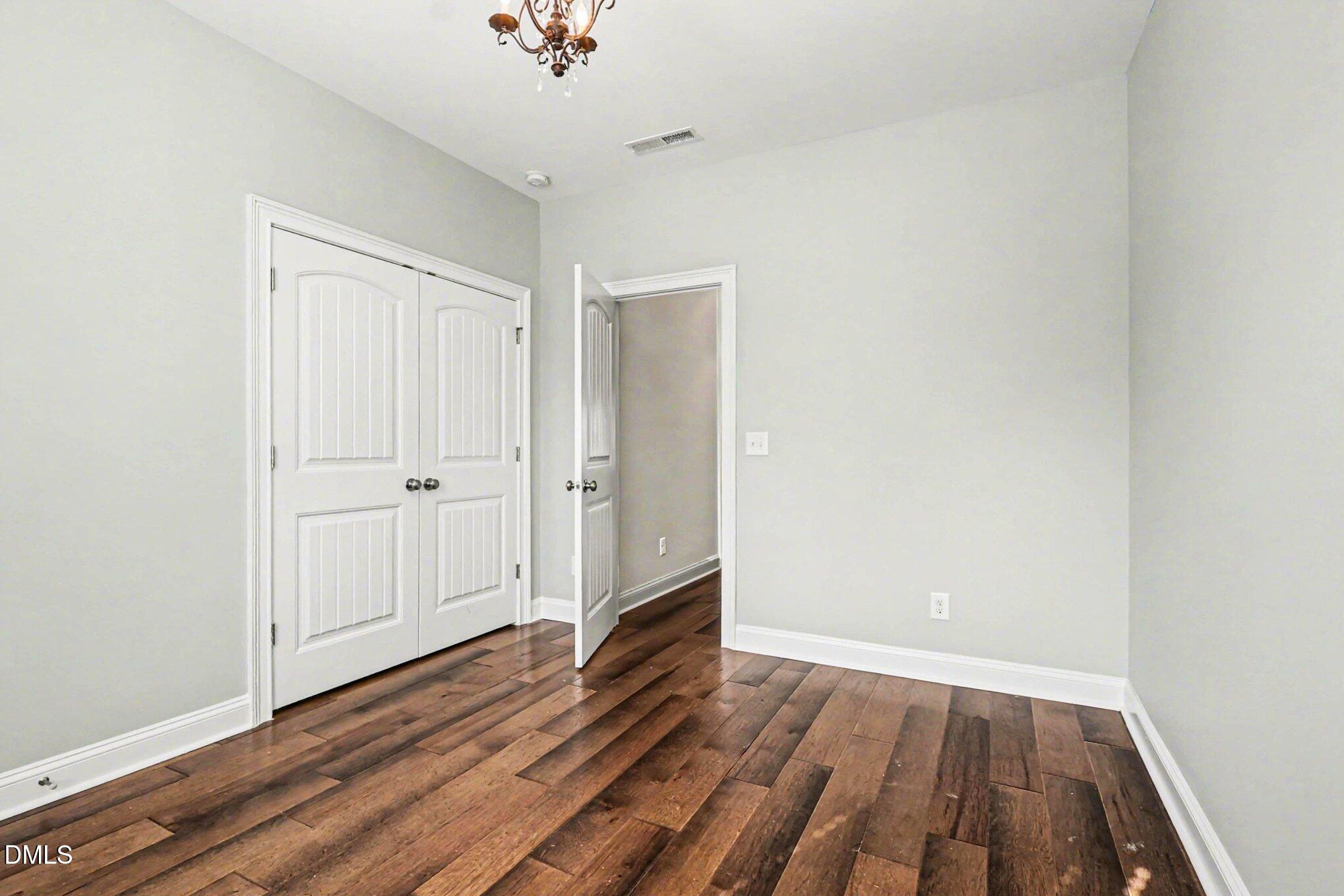 653 Fallon Grove Way Raleigh, NC 27608 - Photo 13 of 38 an empty room with wooden floor