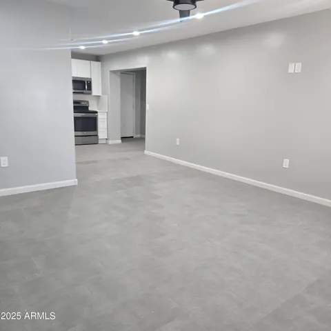 a view of an empty room with a kitchen
