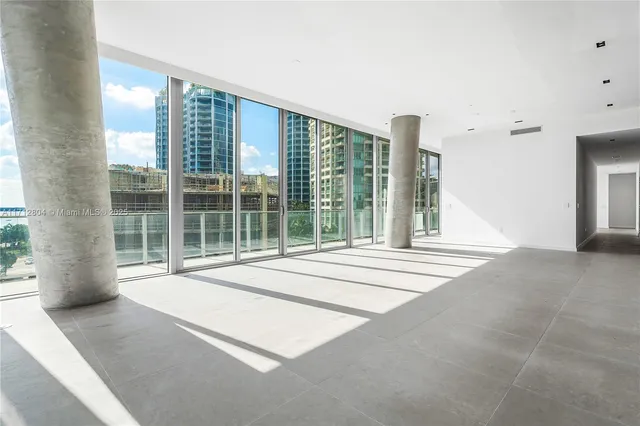a living room with a large window and a chandelier