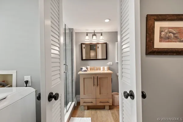 a bathroom with a granite countertop sink a mirror and a shower