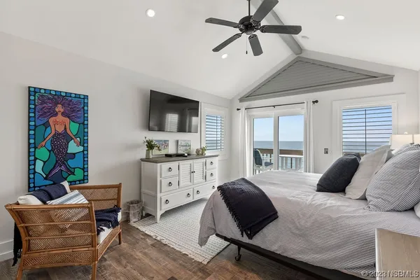 a bedroom with a large bed and a flat tv screen