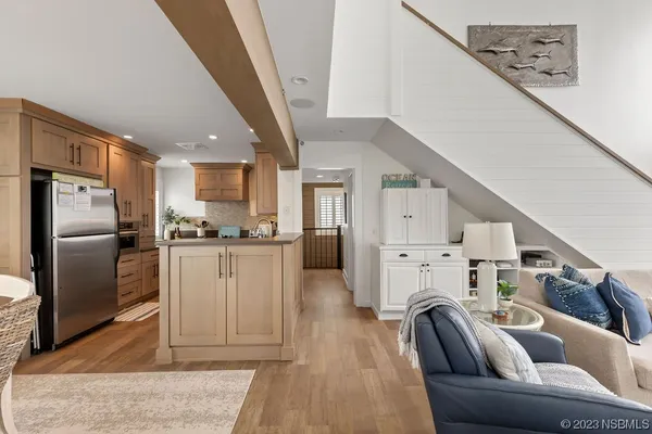 a living room with furniture appliances and a kitchen view