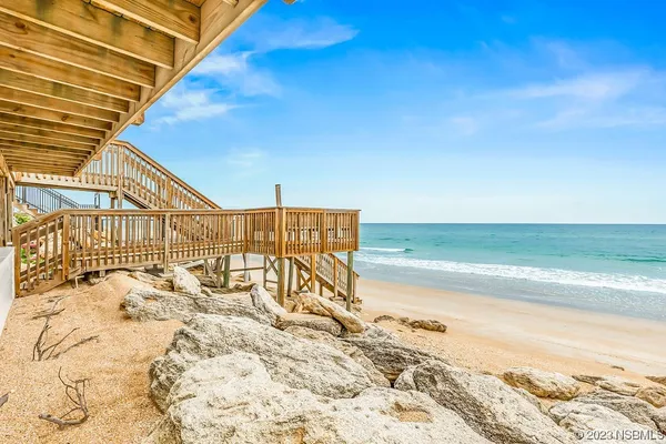 a balcony with chairs and iron fence