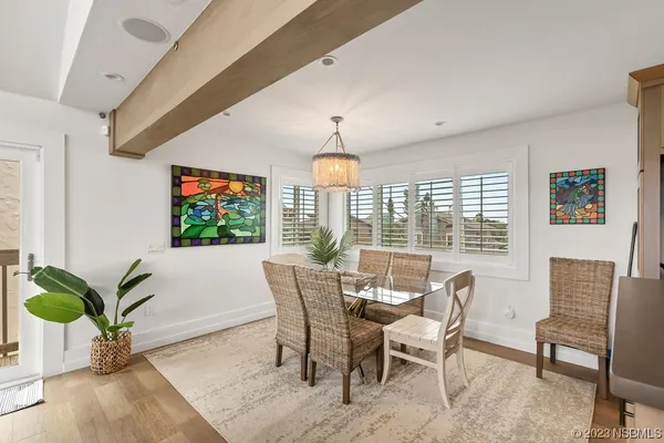 a dining room with furniture potted plants and wooden floor