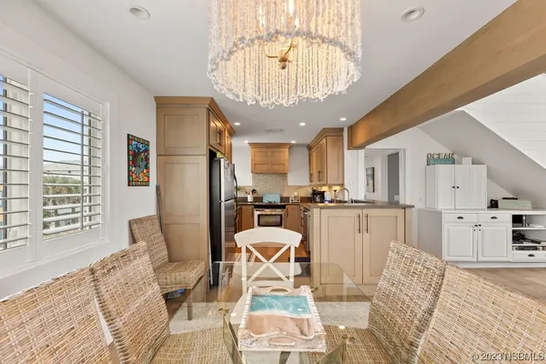 a view of a dining room with furniture a chandelier and wooden floor