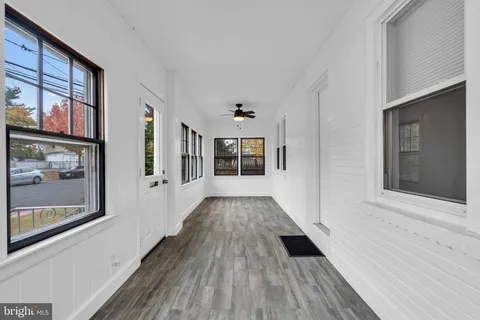 a view of a hallway with wooden floor and windows
