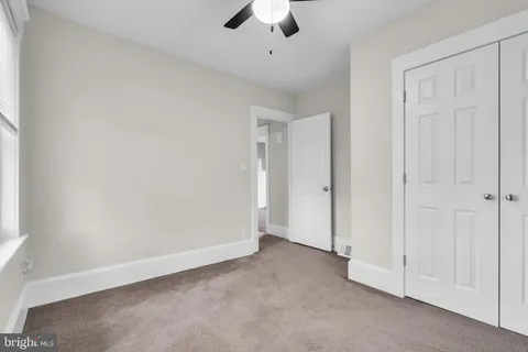 an empty room with chandelier fan