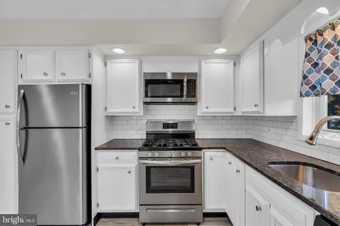 a kitchen with refrigerator a microwave and cabinets