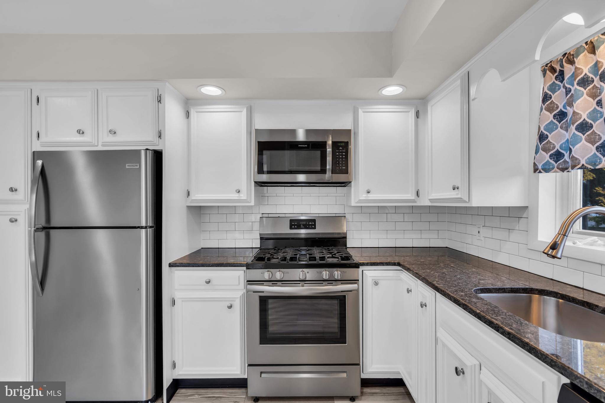 29 Saybrook Avenue Trenton, NJ 08619 - Photo 4 of 31 a kitchen with refrigerator a microwave and cabinets