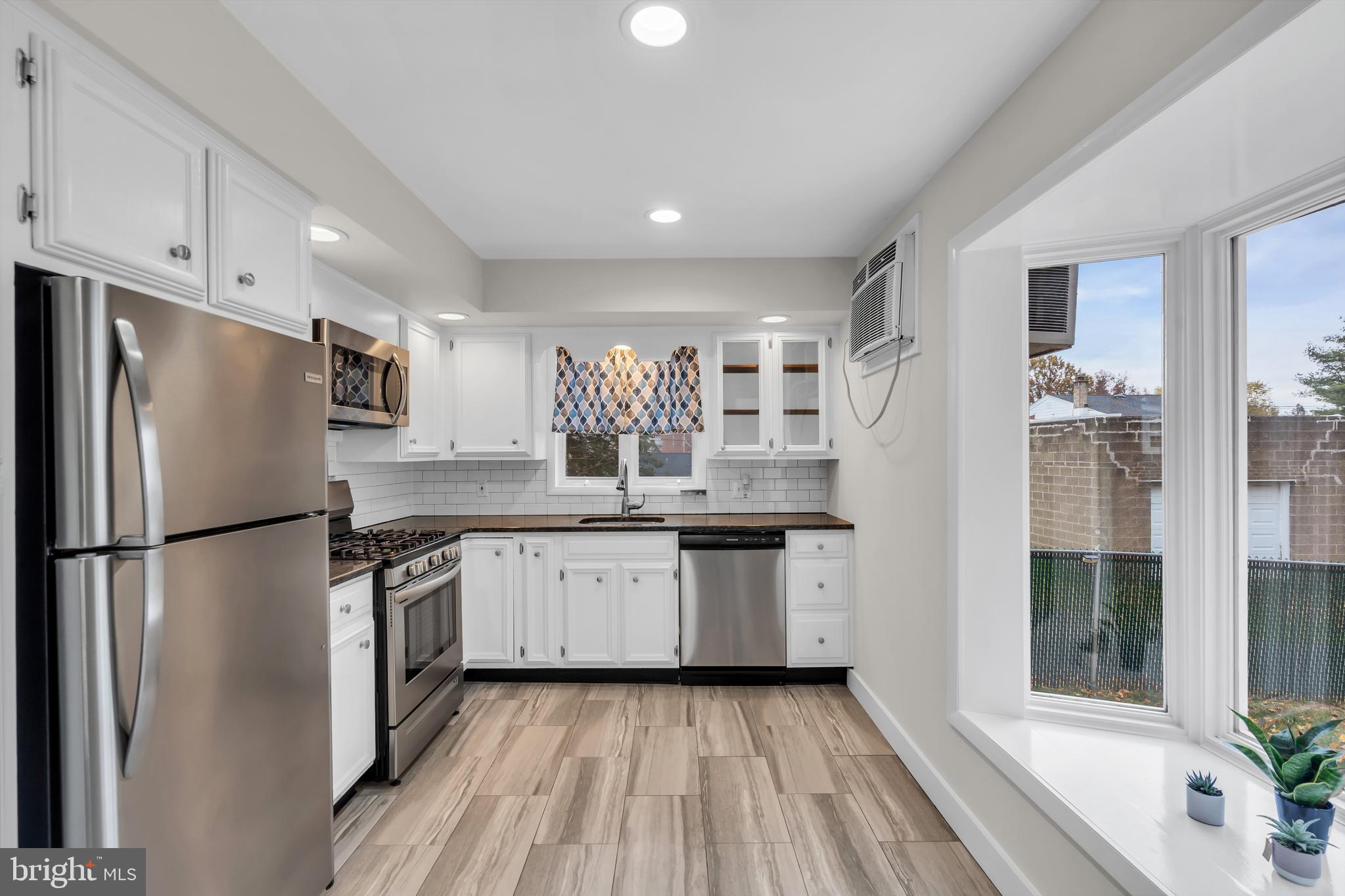 29 Saybrook Avenue Trenton, NJ 08619 - Photo 7 of 31 a kitchen with granite countertop a refrigerator a sink a stove and white cabinets