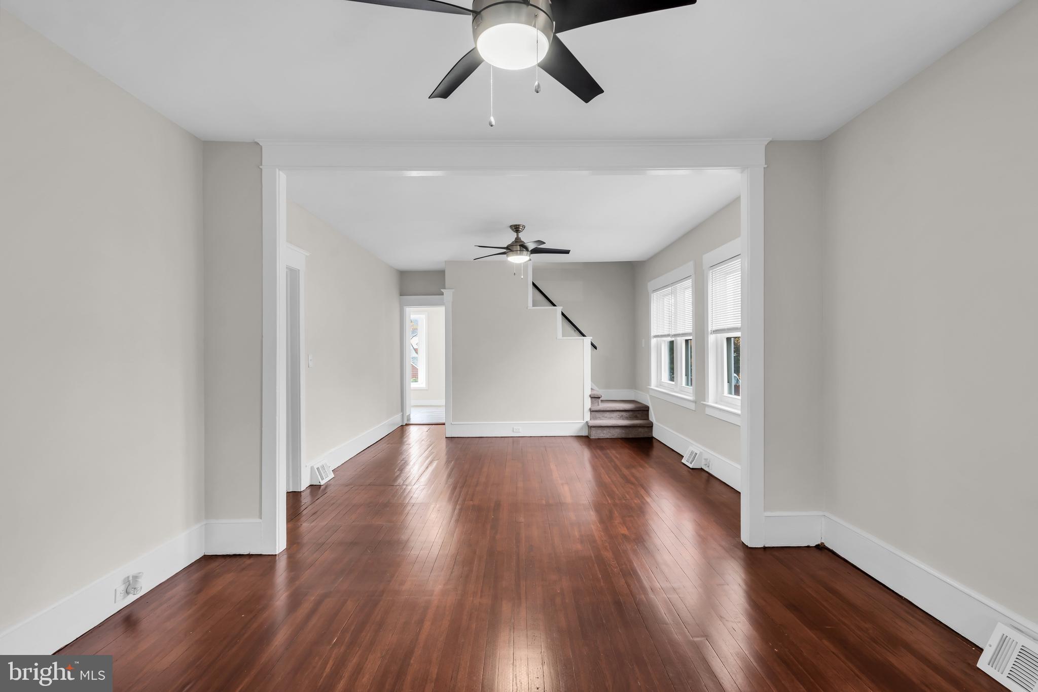 29 Saybrook Avenue Trenton, NJ 08619 - Photo 9 of 31 an empty room with wooden floor chandelier fan and windows