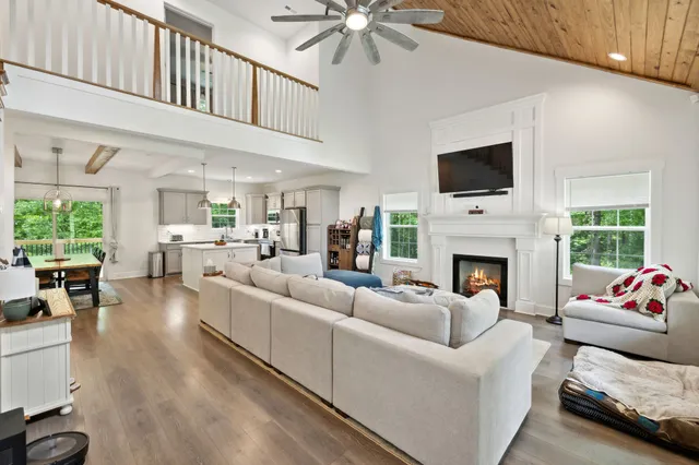 a living room with furniture a fireplace and a flat screen tv