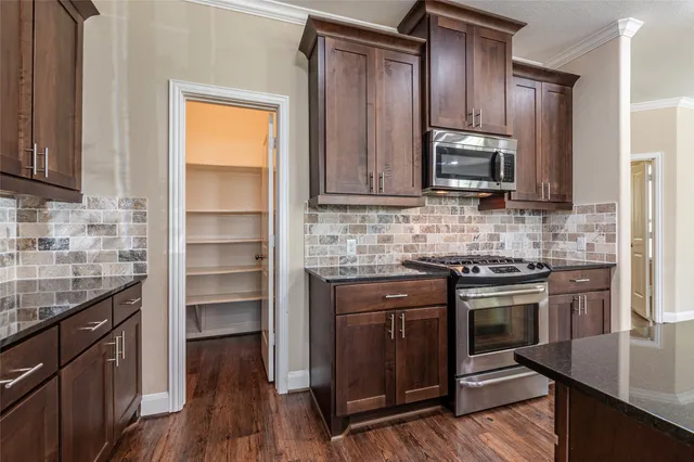a kitchen with stainless steel appliances granite countertop a sink stove and cabinets