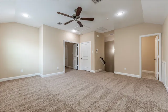 an empty room with ceiling fan and window