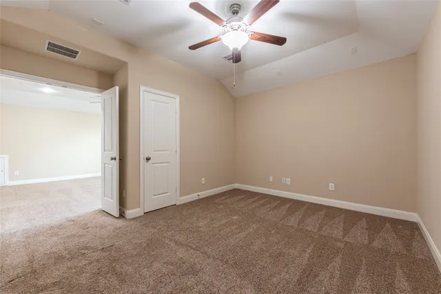 a view of an empty room and a ceiling fan