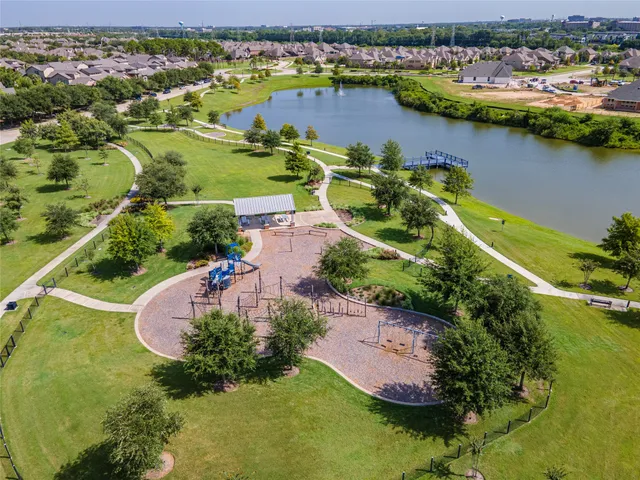 an aerial view of a residential houses with outdoor space and lake view