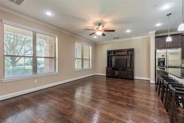 an open kitchen with kitchen island wooden floors and white cabinets
