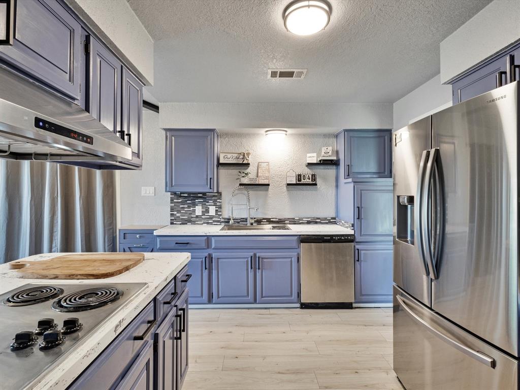 108 Sunview Street Sunnyvale, TX 75182 - Photo 22 of 29 a kitchen with stainless steel appliances granite countertop a stove refrigerator sink and cabinets