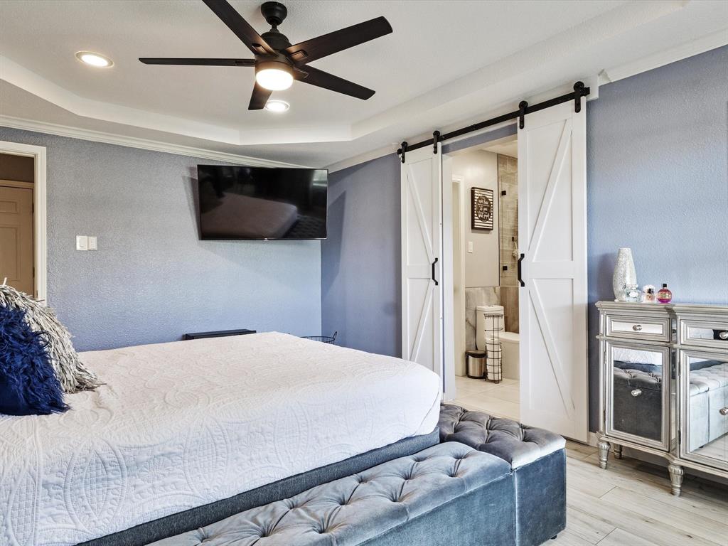 108 Sunview Street Sunnyvale, TX 75182 - Photo 3 of 29 a bedroom with a large bed and a ceiling fan