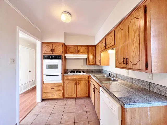 a kitchen with stainless steel appliances granite countertop a sink stove and cabinets