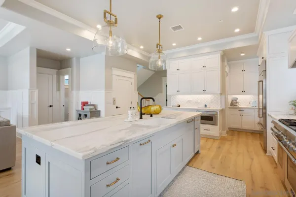 a large kitchen with kitchen island a sink stainless steel appliances and cabinets