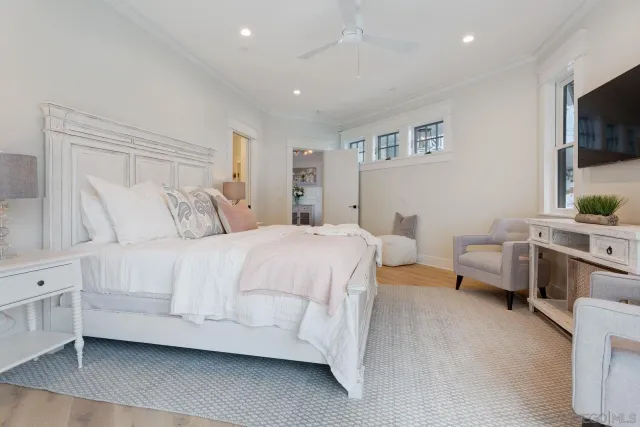 a spacious bedroom with a bed and a flat screen tv