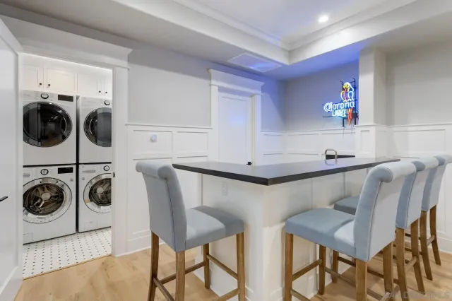 a kitchen with stainless steel appliances kitchen island granite countertop a table chairs refrigerator and microwave