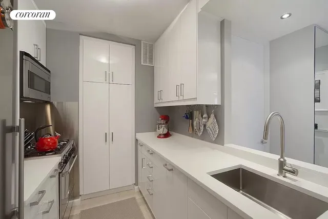 a kitchen with stainless steel appliances granite countertop a sink and a refrigerator
